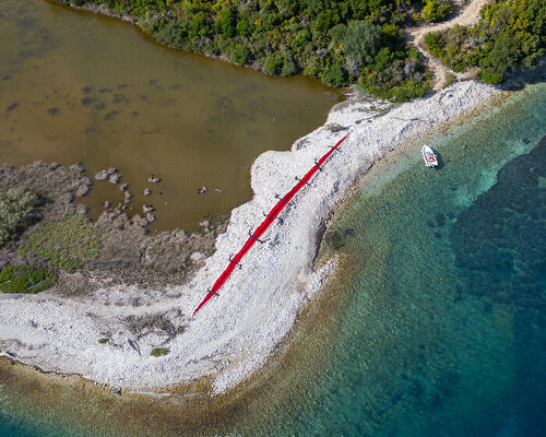 red wound and black stitches turn bulldozer scar into land art by the krank in corfu